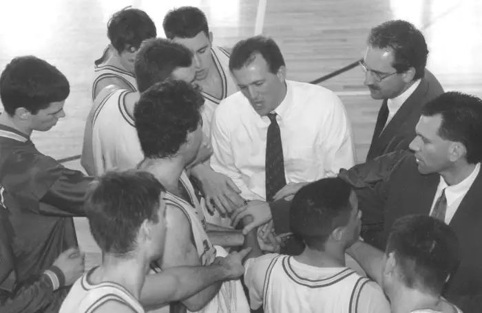 A black and white photo of Tony Wingen with his team on the court. 